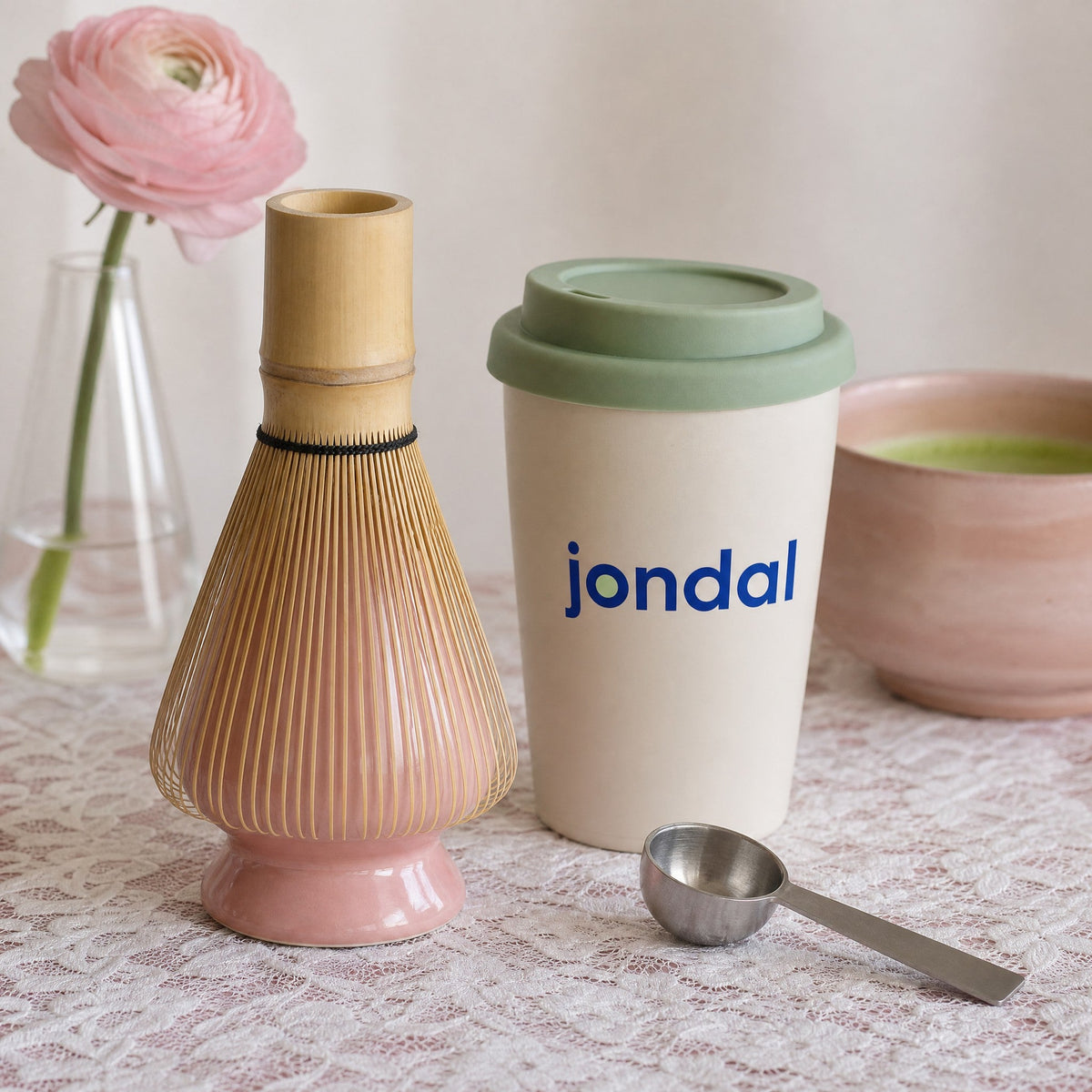 Bamboo chasen on a pink holder, Jondal to go cup and measuring spoon on a lace tablecloth