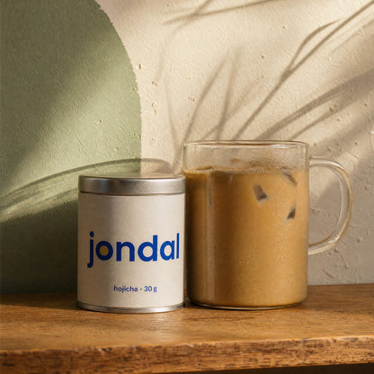 Jondal hojicha tin next to an iced hojicha latte